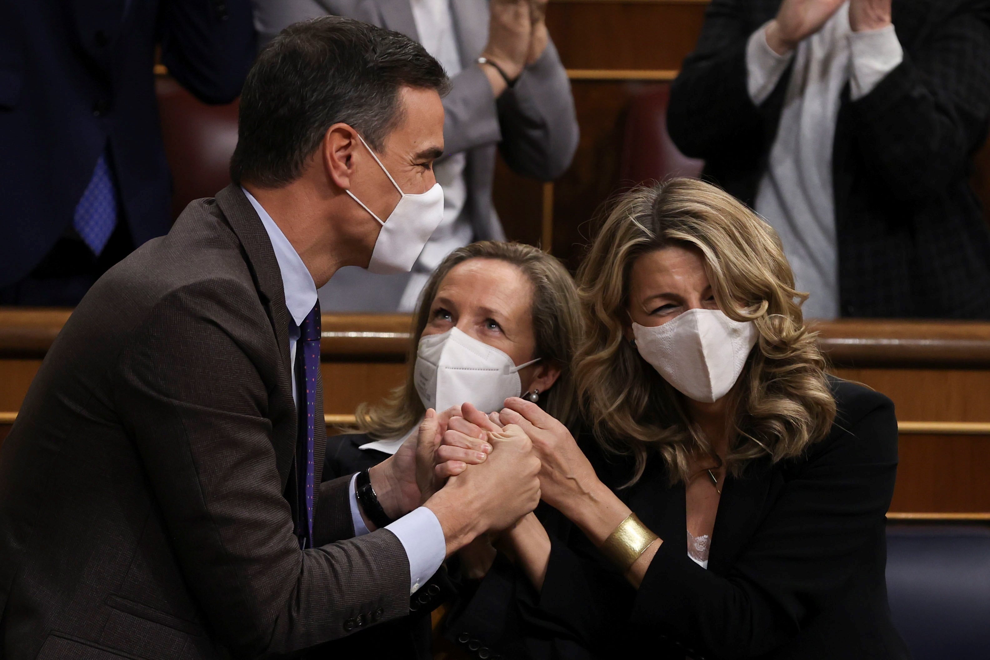 MADRID, 03/02/2022.- El presidente del Gobierno, Pedro Sánchez (i), la vicepresidenta primera Nadia Calviño (c), y la vicepresidenta y ministra de Trabajo, Yolanda Díaz, se felicitan después de que el pleno del Congreso de los Diputados votara a favor de la convalidación de la reforma laboral pactada por el Gobierno con los agentes sociales, este jueves en Madrid. EFE/Kiko Huesca