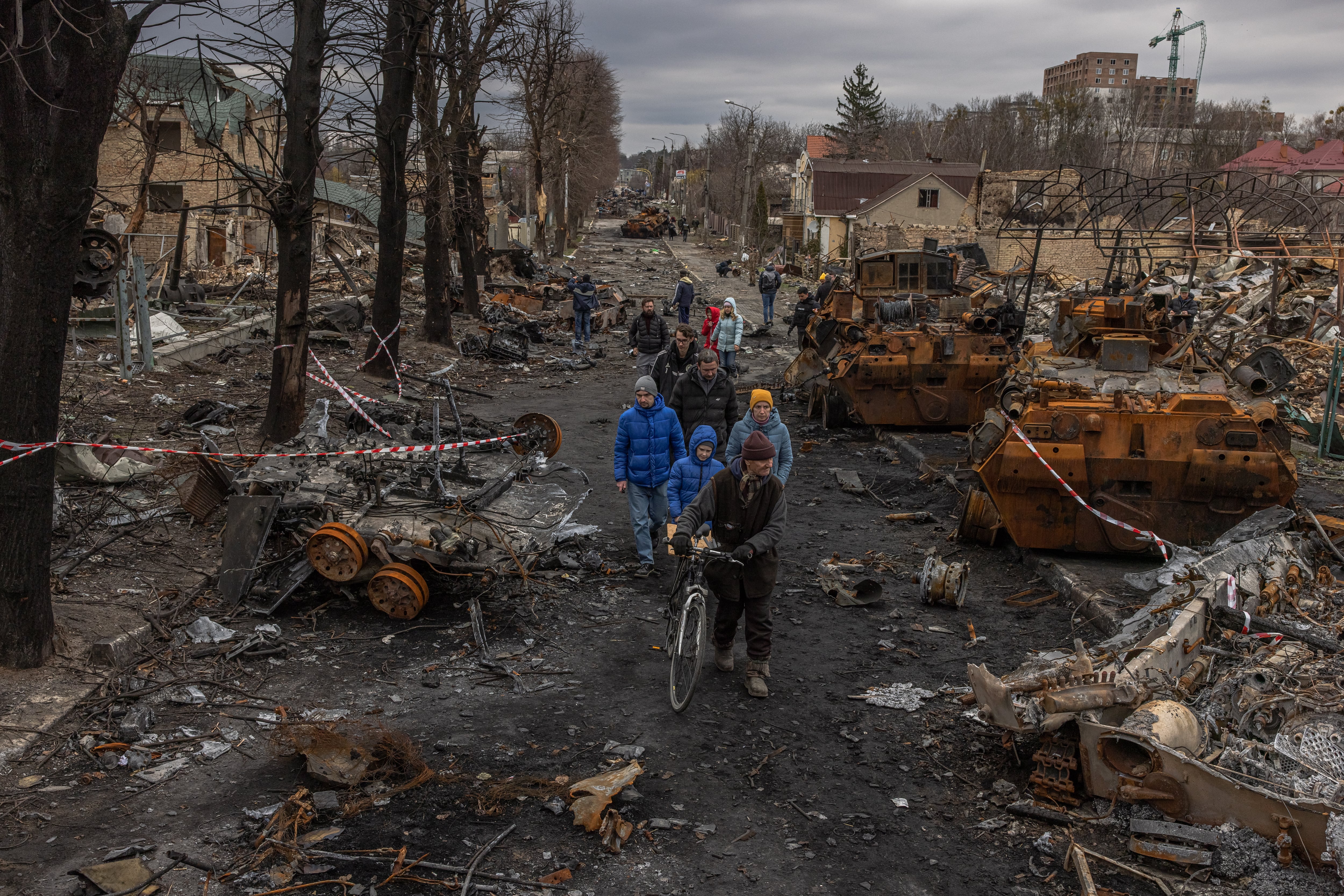 Un grupo de vecinos pasean por las calles de Bucha, escenario de una de las peores matanzas en los primeros seis meses de guerra (EFE/EPA/ROMAN PILIPEY).