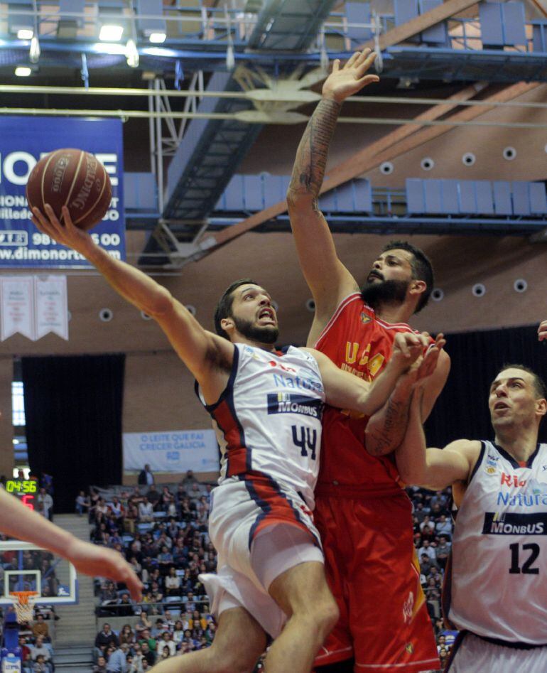 El base del Obradoiro, Pepe Pozas entra a canasta ante la oposición del jugador del Murcia, Victor Faverani durante el encuentro de la jornada 29 de la liga ACB que se disputa en el Multiusos de Sar de Santiago de Compostela