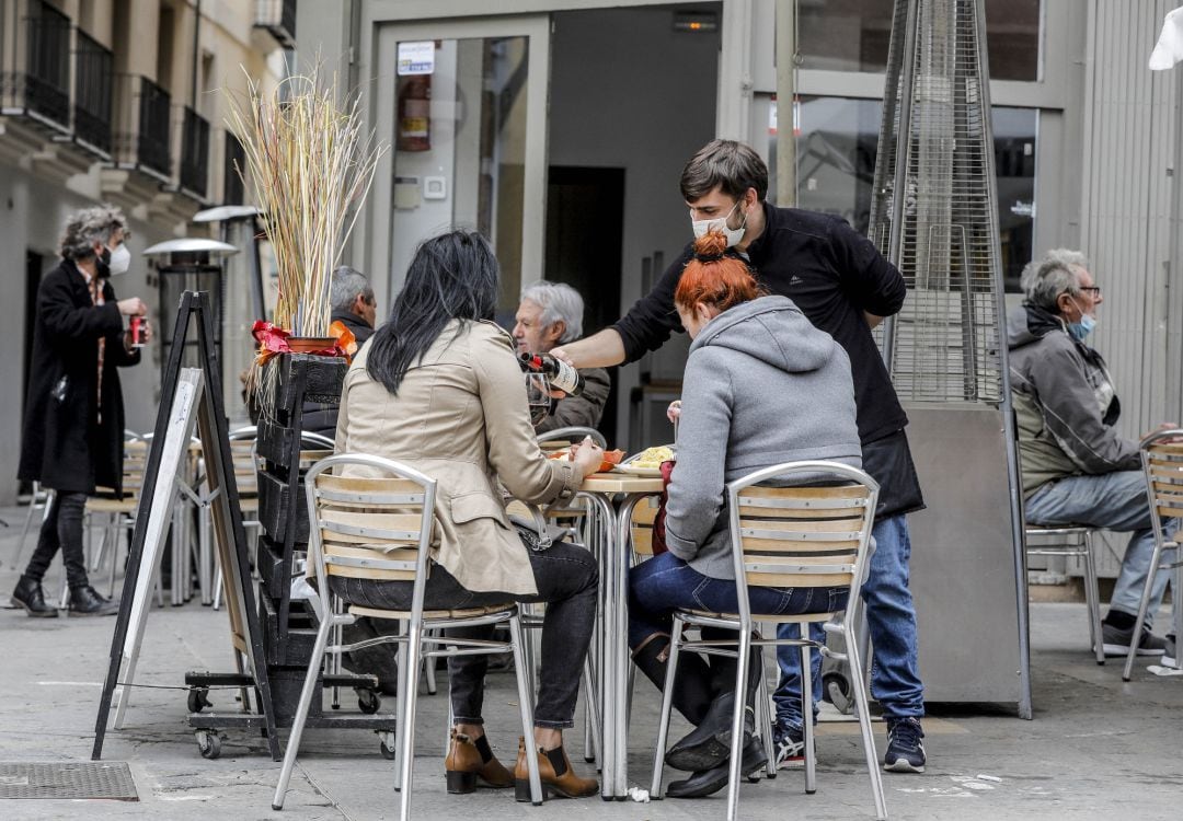 Un camarero atiende a dos clientas en una terraza el primer día de la apertura de la hostelería en València tras la pandemia de la Covid-19.