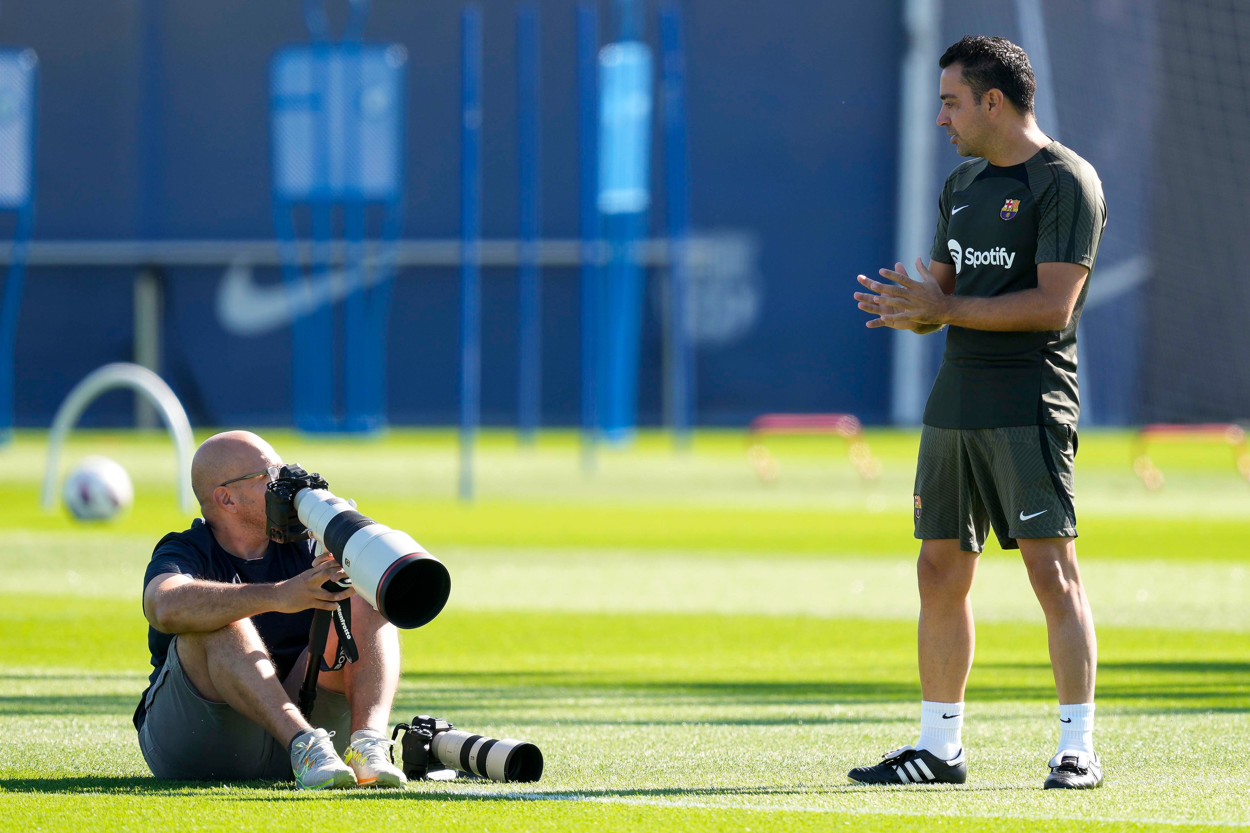 El entrenador del FC Barcelona, Xavi Hernandez, conversa con el fotógrafo del club durante el entrenamiento