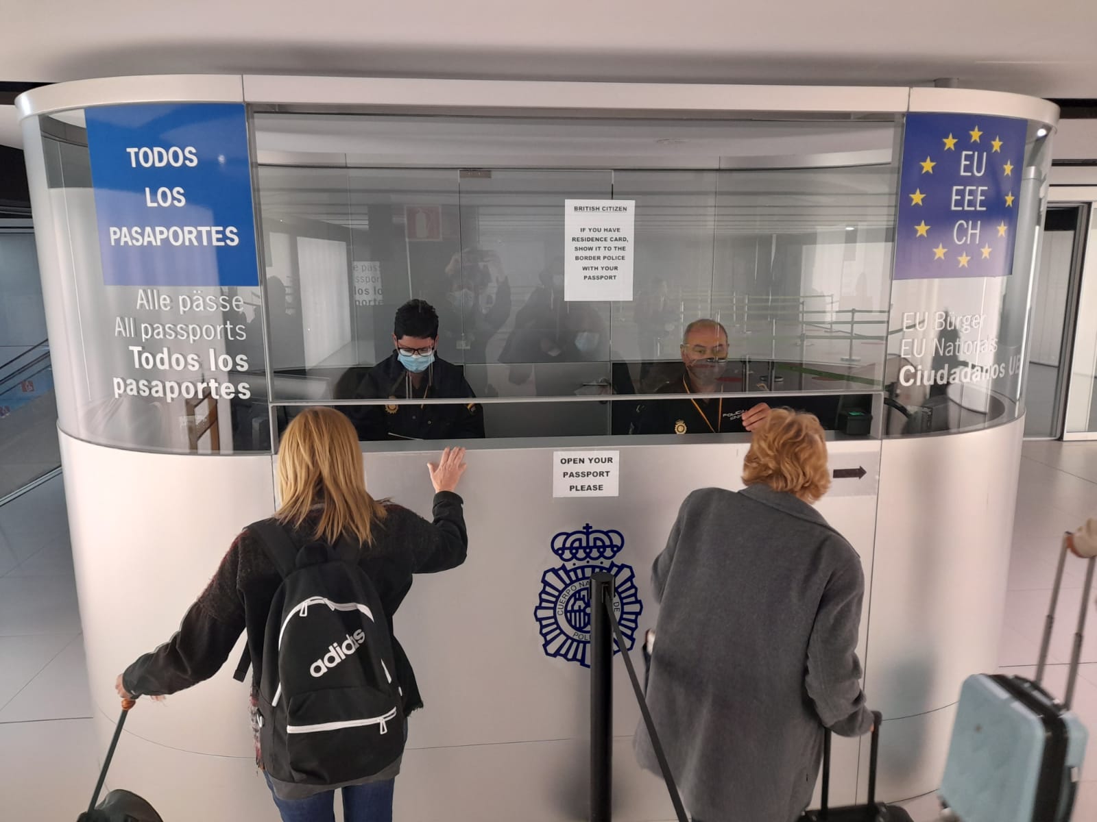 Los policías que se encargan del filtro de entrada y salida de viajeros en España comprueban las identidades de los pasajeros en el aeropuerto de Corvera