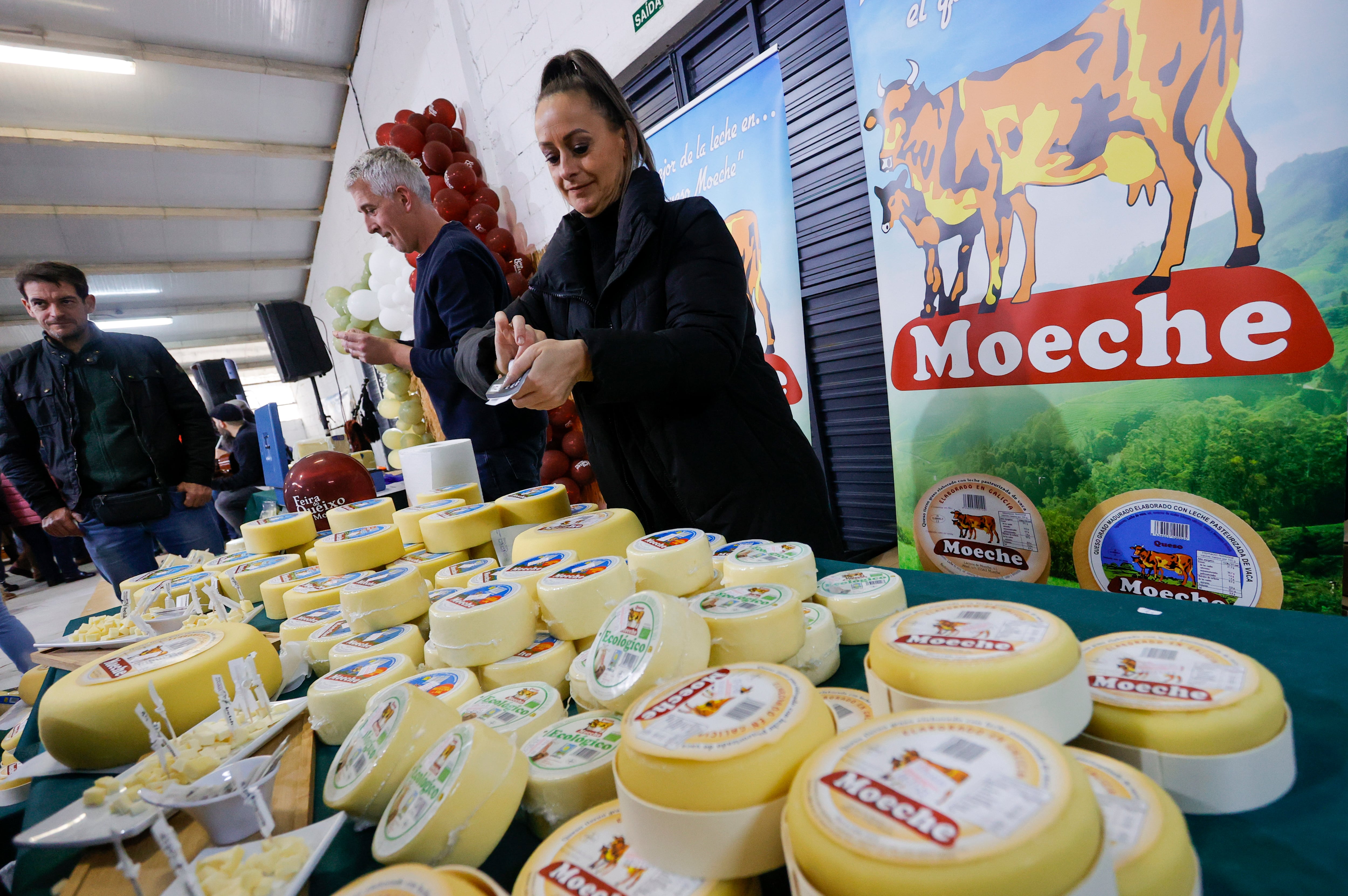 MOECHE, 26/03/2023.- Uno de los fabricantes expone sus quesos durante la quinta edición de la feria del queso de Moeche, este domingo. EFE/ Kiko Delgado.