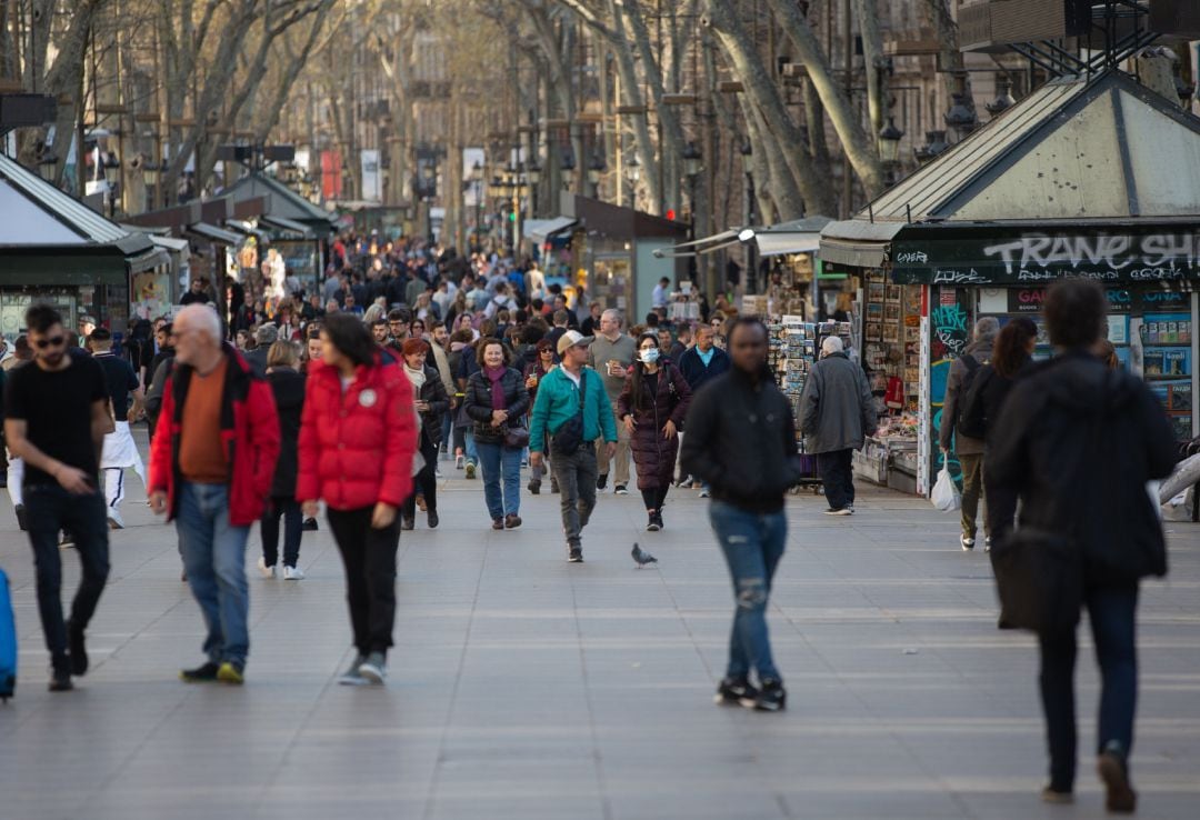 Varias personas caminan por las Ramblas de Barcelona.