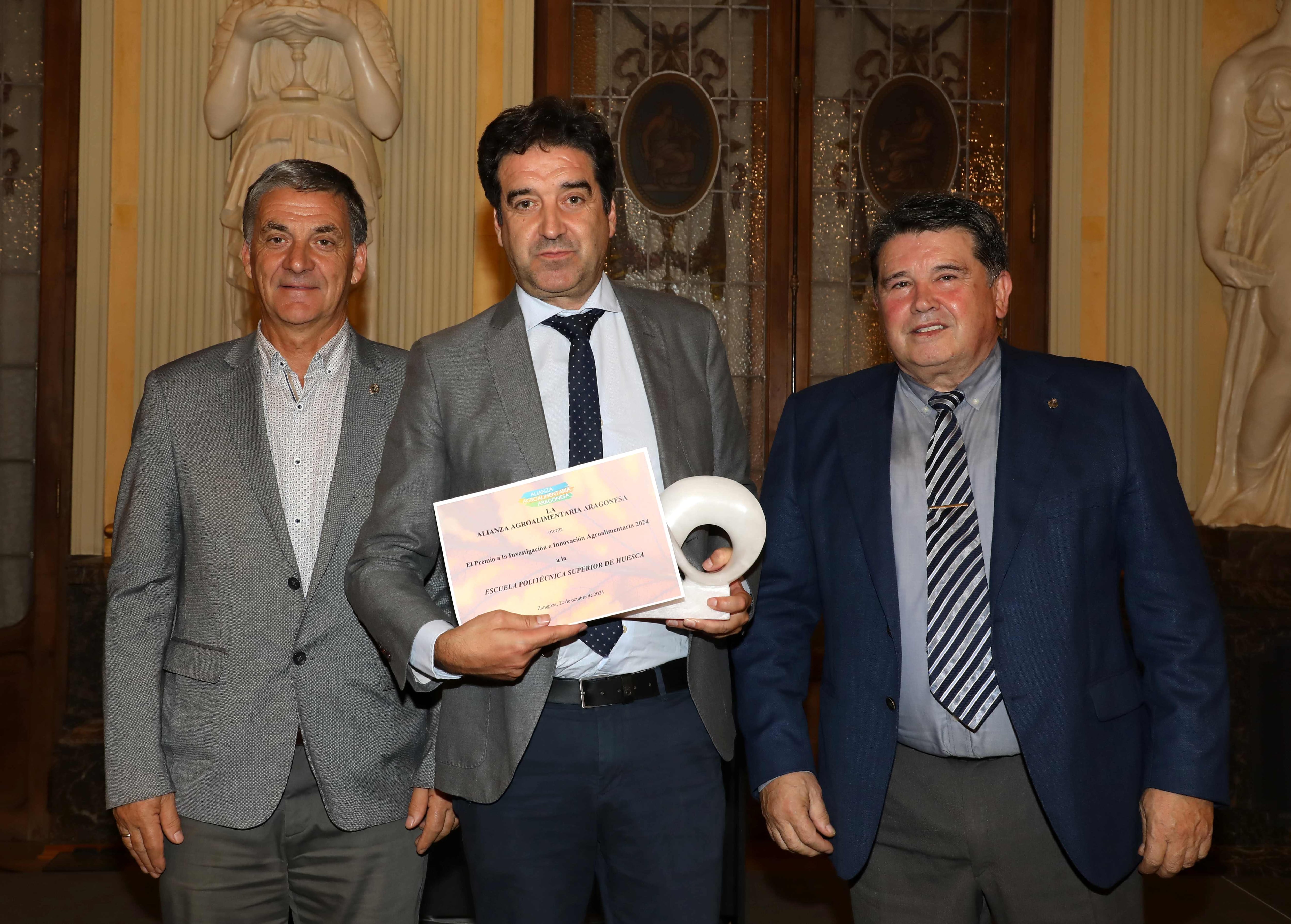 El director de la escuela, Javier García, recibe el premio entregado por Ángel Jiménez. Foto: Agencia Almozara