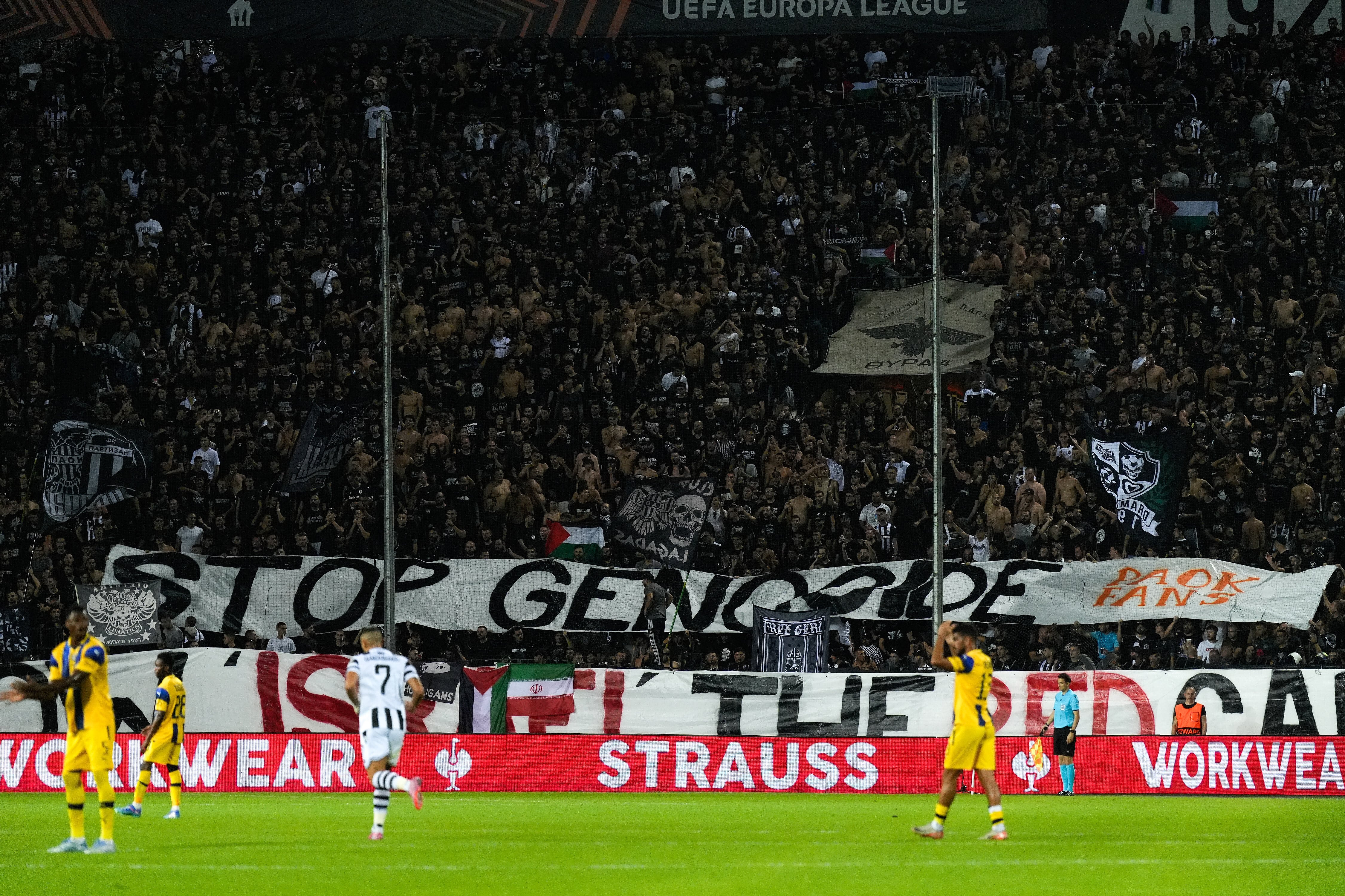 Los aficionados del PAOK levantan una pancarta que dice "paren el genocidio - muestren la tarjeta roja a Israel" durante el partido de fútbol entre el PAOK y el Maccabi Tel Aviv en la UEFA Europa League