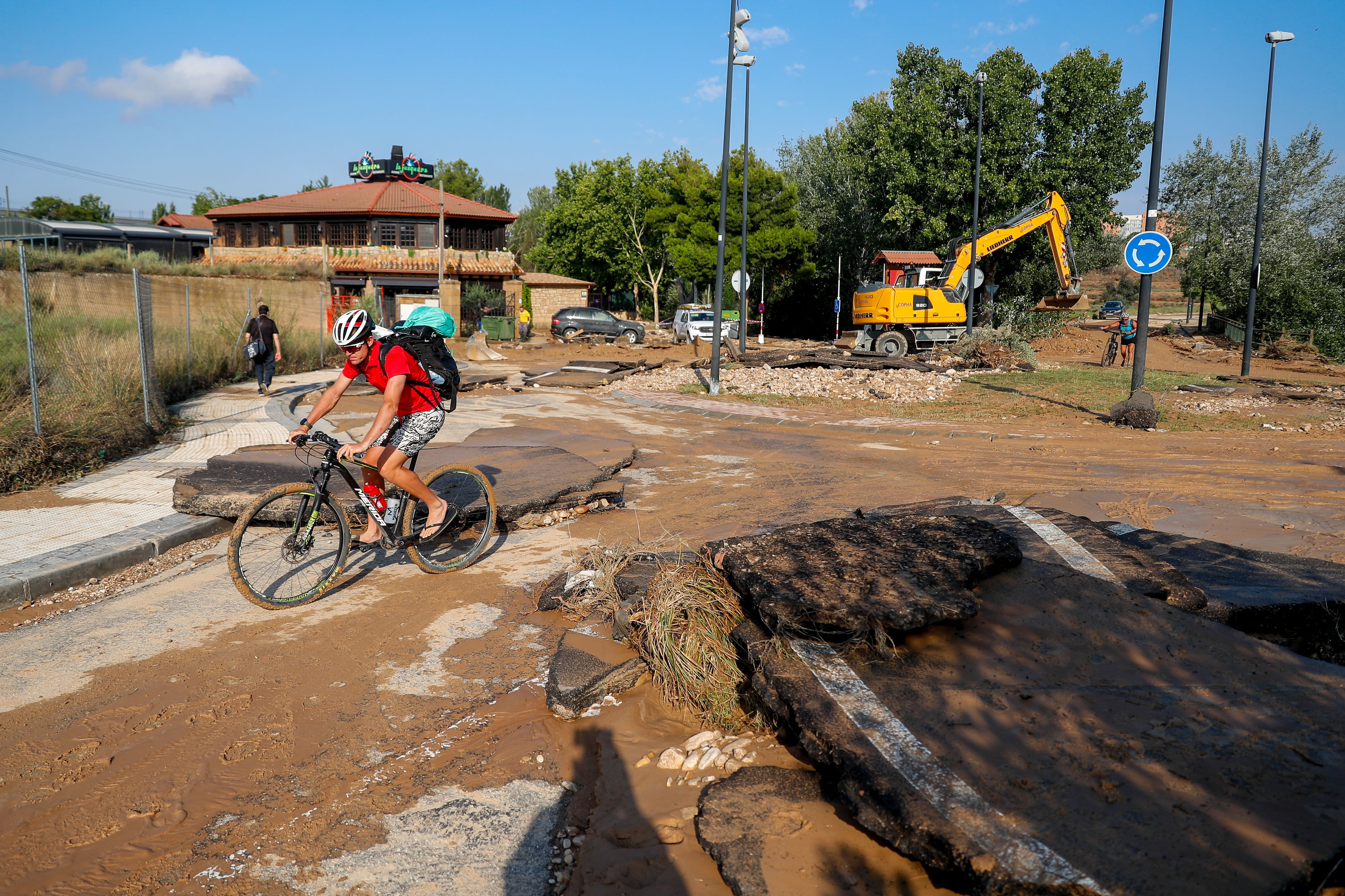 Un ciclista pasa por una zona dañada este viernes tras la fuerte tormenta caída la tarde deayer en Zaragoza.