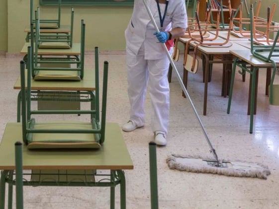 Dos trabajadoras limpieza desinfectan un aula, en una imagen de archivo