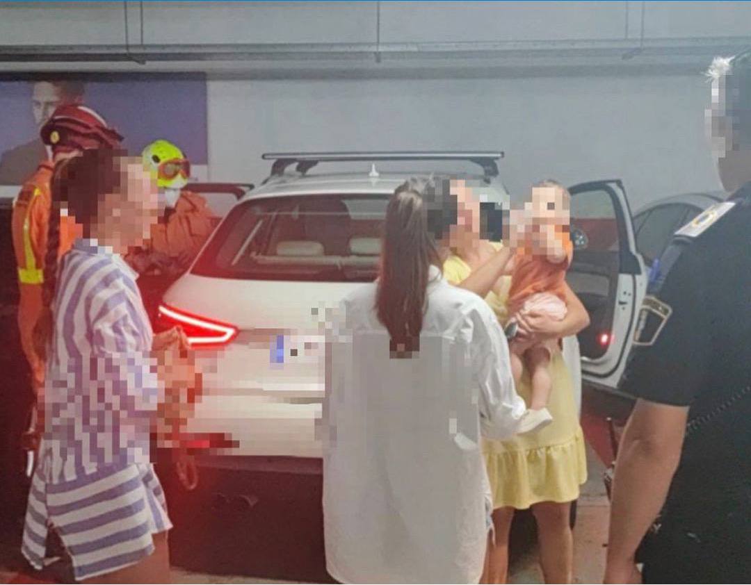 Agentes de la Policía Local y Bomberos atendiendo al pequeño rescatado de un coche en Gandia.