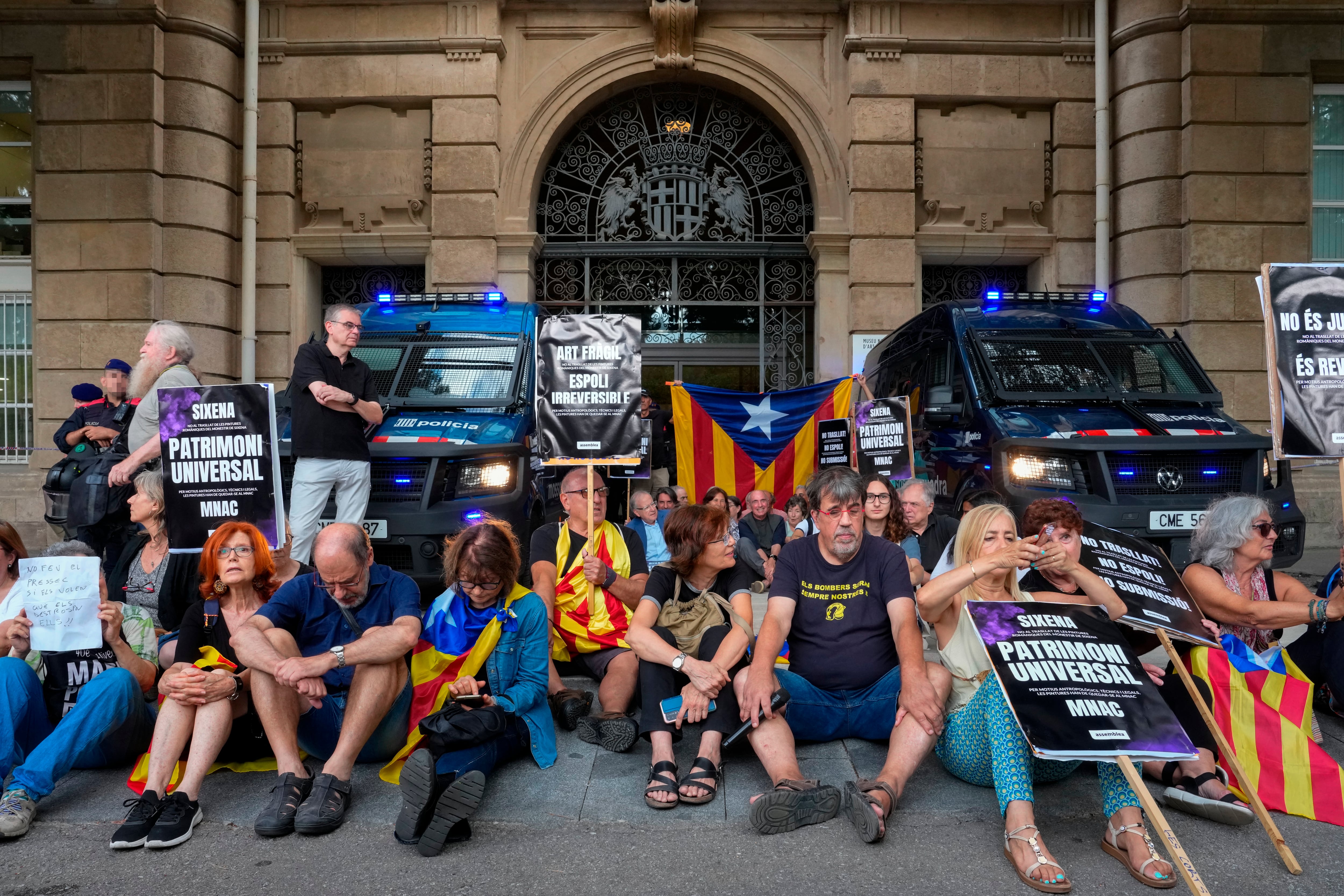 GRAFCAT880. BARCELONA, 28/07/2025.- Varias decenas de personas convocadas por la ANC en protesta por el traslado de las pinturas de Sijena, bloquean la entrada de oficinas del Museo Nacional de Arte de Cataluña (MNAC), donde este lunes se espera la visita de técnicos del gobierno de Aragón para hacer un estudio de las pinturas de Sijena y examinan la documentación sobre su tratamiento y conservación con vistas al traslado al monasterio oscense. EFE/Enric Fontcuberta
