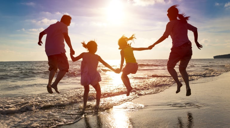 Imagen de una familia divirtiéndose en una playa. 