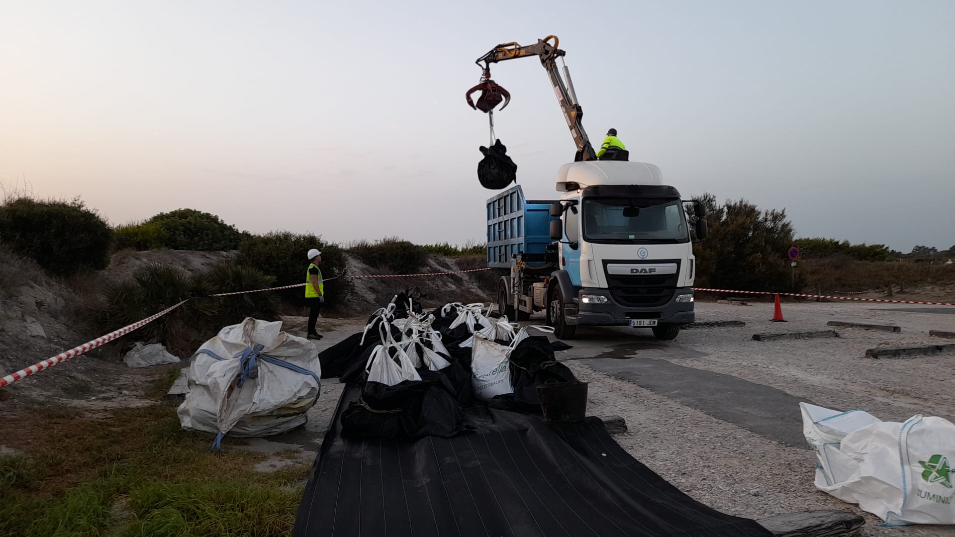 Un camión retira los restos del vertido de hidrocarburos en la playa de El Saler en Valènci