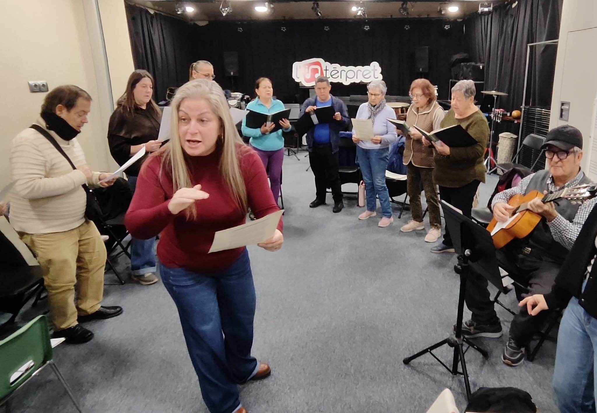 La Paula Costes, professora de la coral de la Mariola, donant indicacions al grup abans de repetir una estrofa. A la guitarra, en Paco, de qui també es canten composicions com "Pedro el solitario".