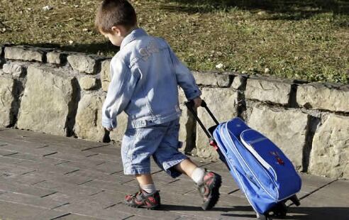 Un niño arrastra su mochila camino de la escuela