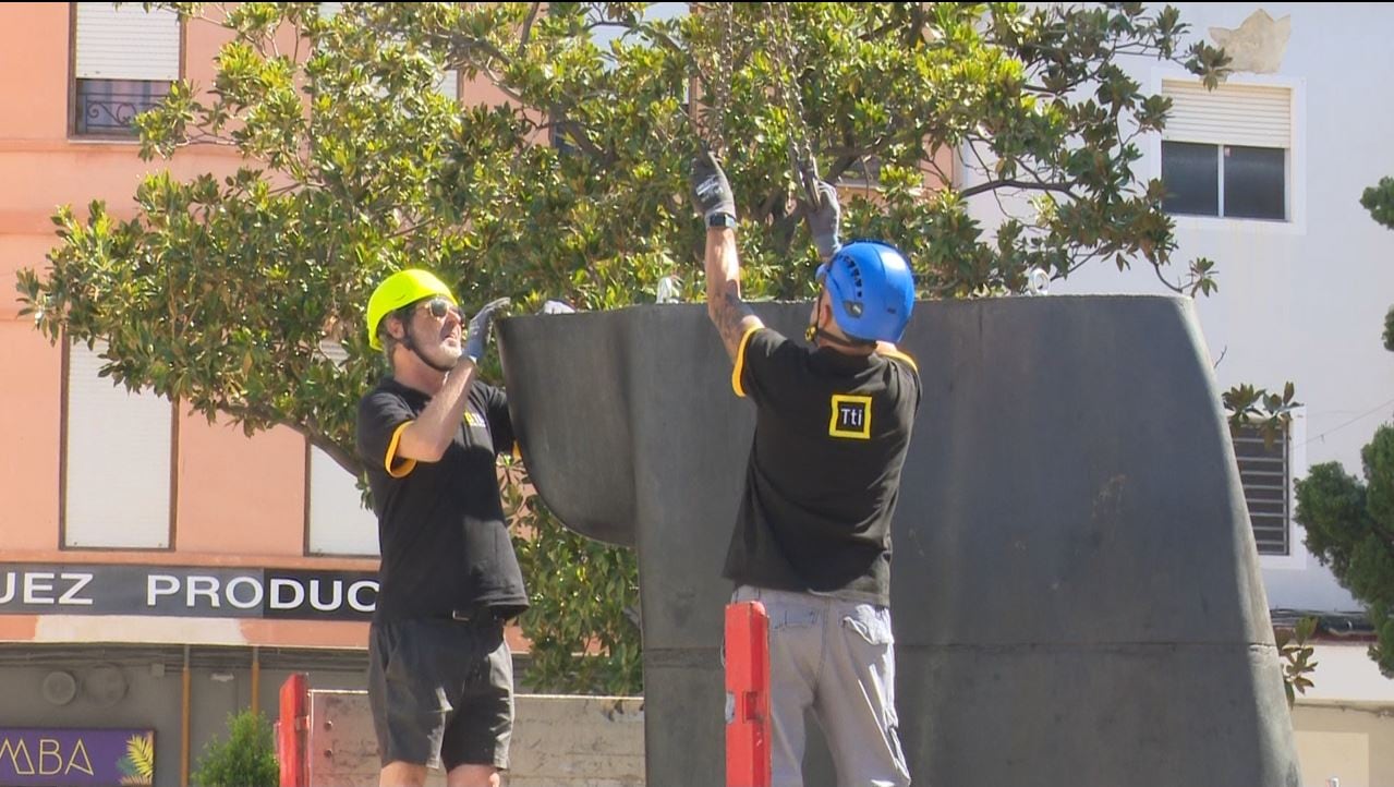 Dos operarios durante los trabajos de montaje de las esculturas de Jaume Plensa en la plaza Major de Gandia.