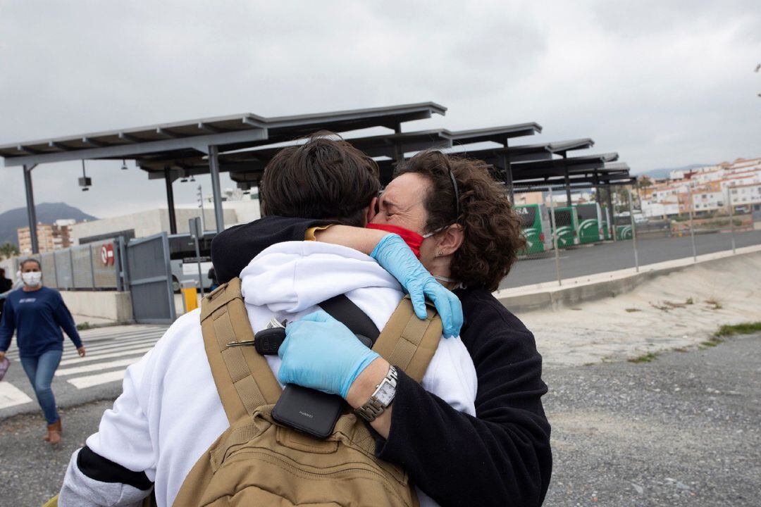 Madre recibiendo en una estación de autobuses a su hijo