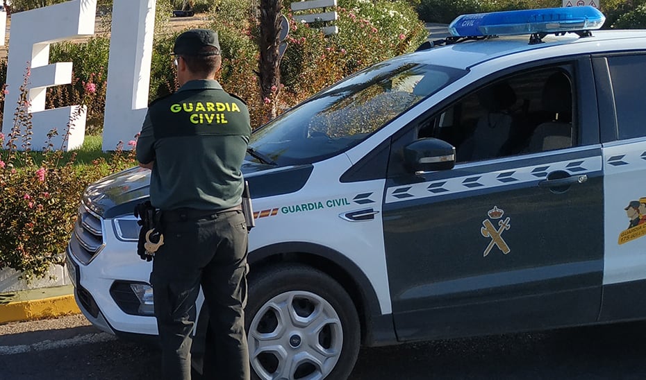 Un agente de la Guardia Civil junto a un vehículo oficial del cuerpo