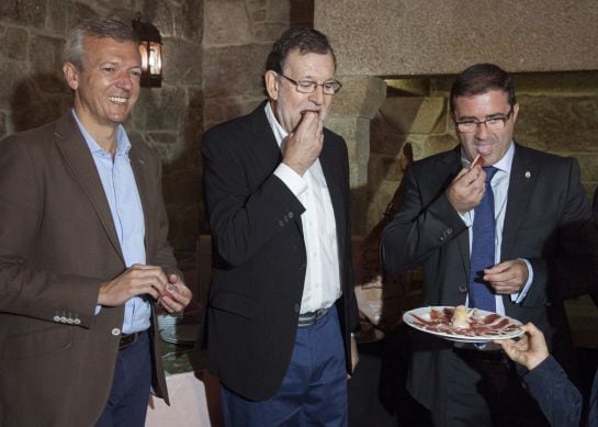 GRA112. A CAÑIZA/MOS (PONTEVEDRA), 14/09/2016.- El presidente del Gobierno en funciones, Mariano Rajoy (c); el vicepresidente de la Xunta, Alfonso Rueda (i), y el alcalde de A Cañiza (Pontevedra), Miguel Domínguez (d), degustan una tapa de jamón durante s