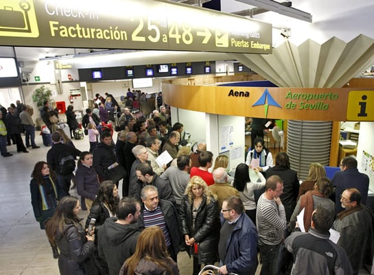 Gran número de personas ante el centro de información de AENA del aeropuerto de Sevilla, cuyo cierre provocado por el abandono masivo de sus puestos de trabajo de los controladores aéreos, ha afectado a miles de viajeros.