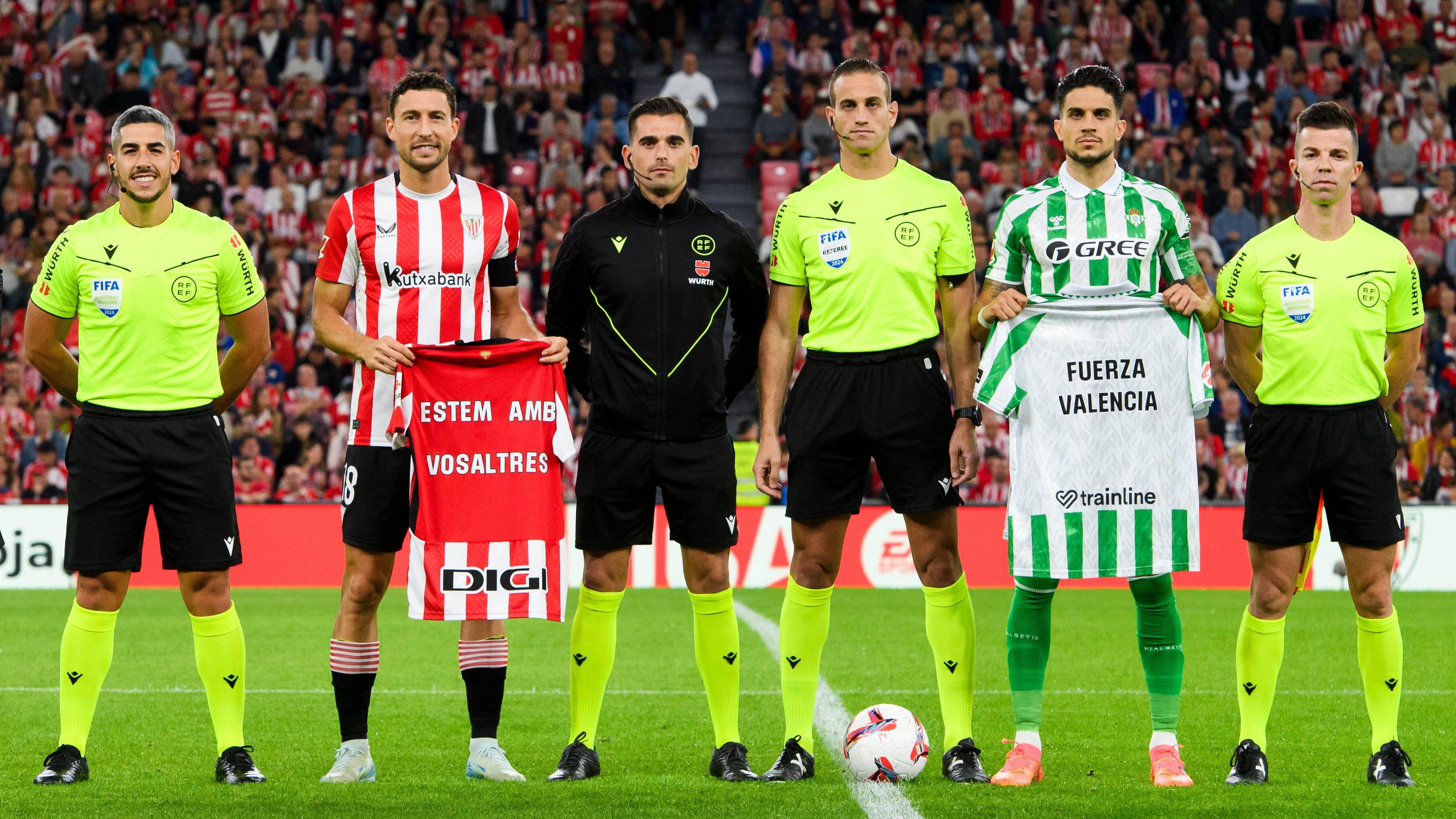 Los capitanes del Athletic y el Betis, De Marcos y Bartra, posan con sendas camisetas de apoyo a las víctimas de la DANA antes del inicio del partido