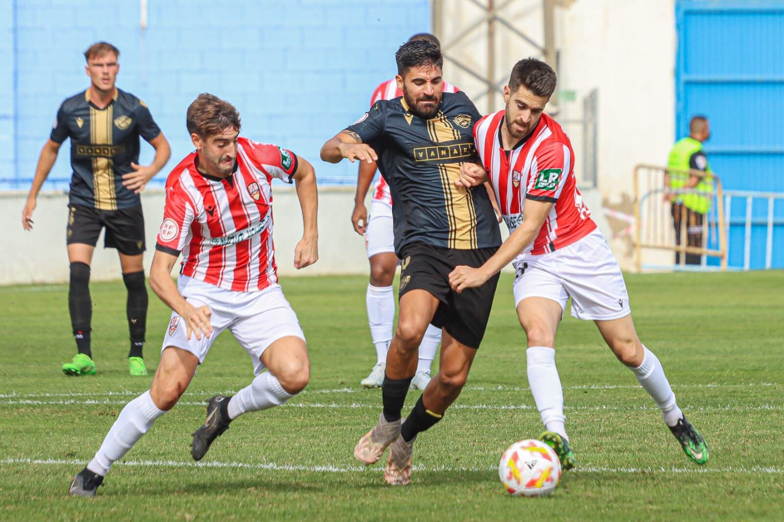 Xavi Boniquet y Cristian Fernández enciman a Carlos Carmona durante una acción del partido disputado en Alicante / CF Intercity