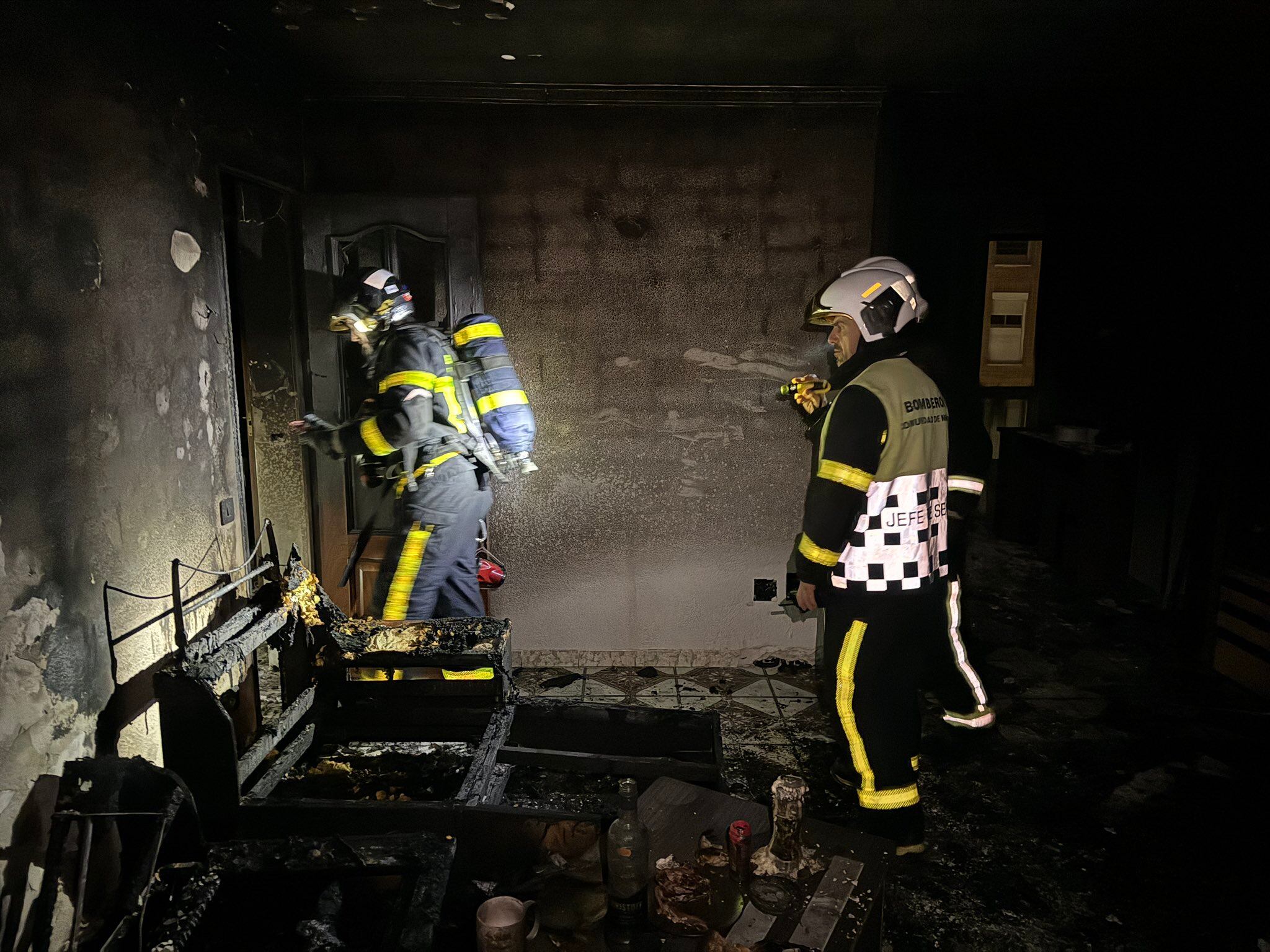 Los bomberos actuando en el interior de la vivienda