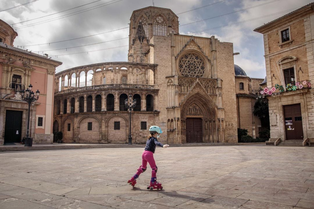 Una niña patina en una vacía plaza de la Virgen de València, en el día en el que más de seis millones de niños menores de 14 años han podido salir a la calle en el caudragésimo tercer diái de estado de alarma