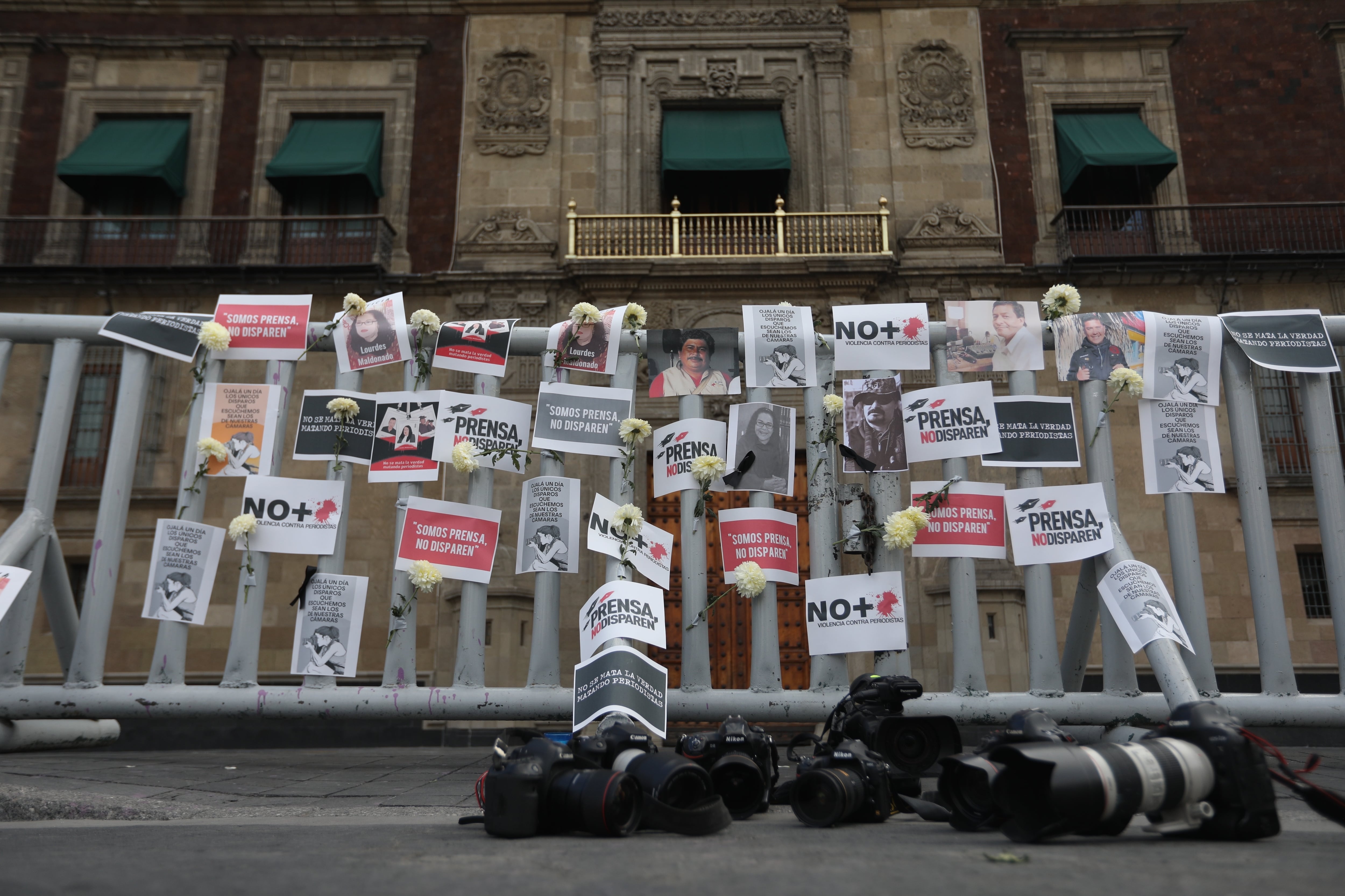 Carteles, flores, retratos y cámaras fotográficas en el suelo como acto de protesta por los asesinatos a periodistas en  Ciudad de México.