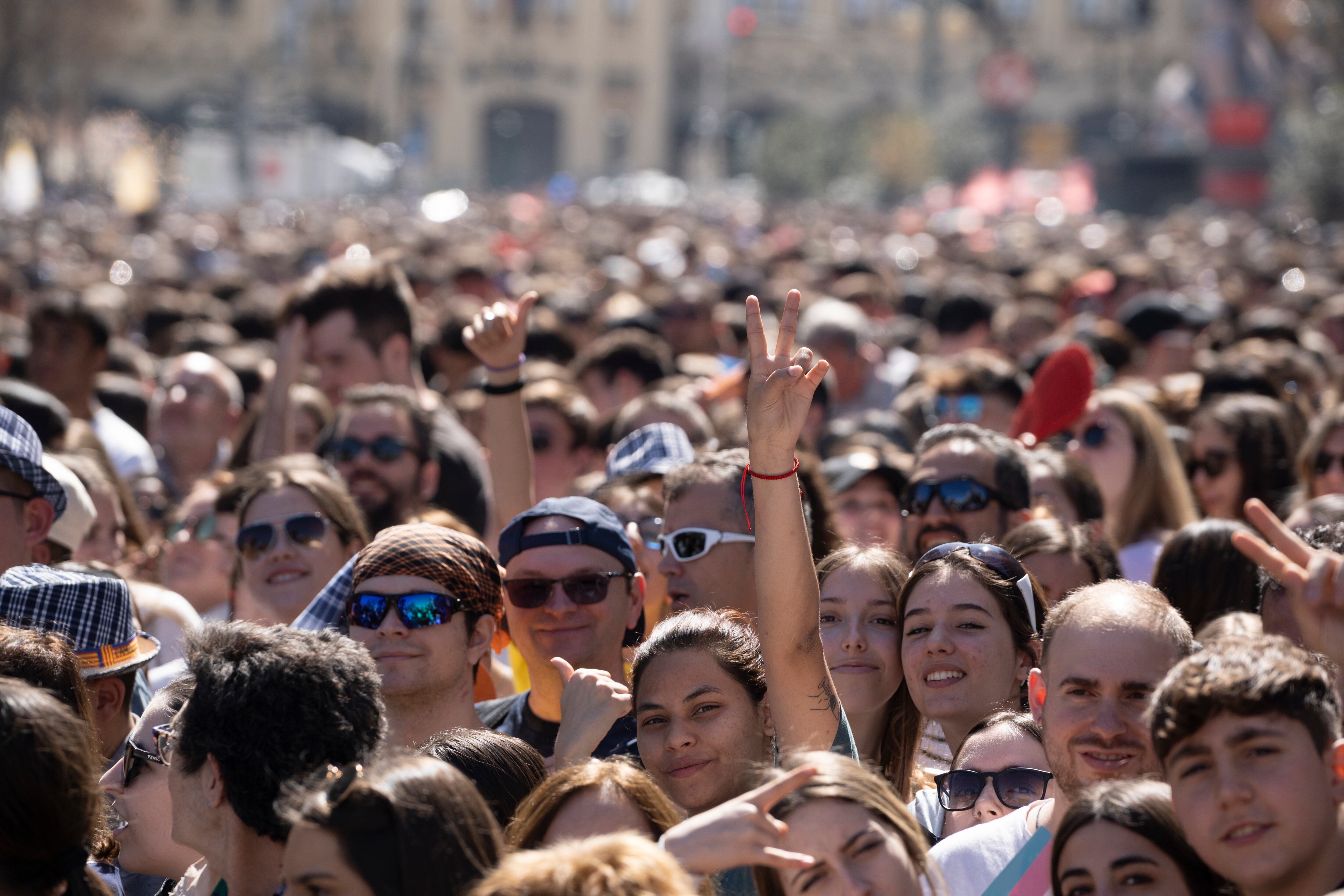 Una multitud de personas presencia una de las mascletàs de la plaza del Ayuntamiento de València durante las Fallas de 2023