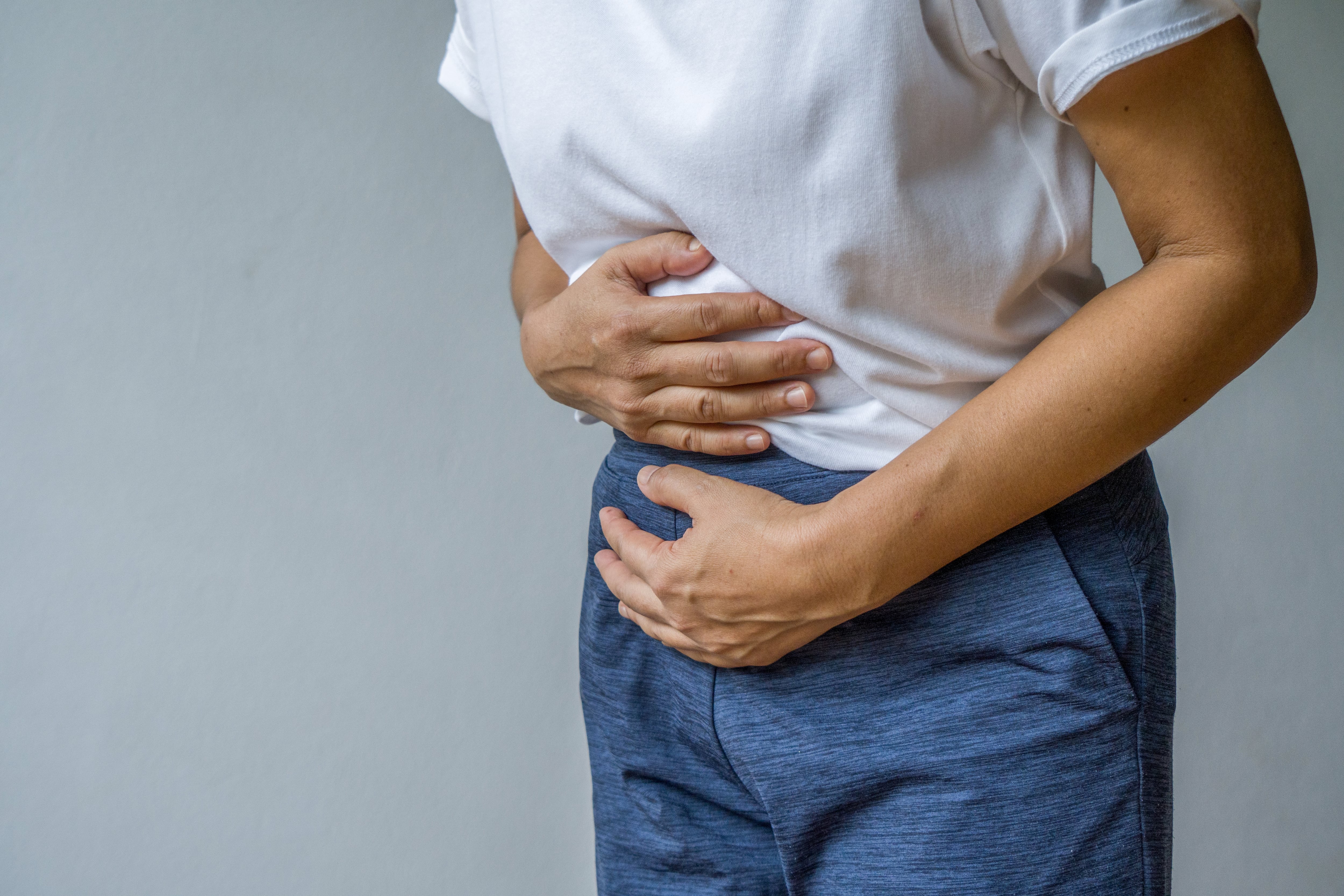 Una mujer se toca el abdomen como símbolo de malestar digestivo