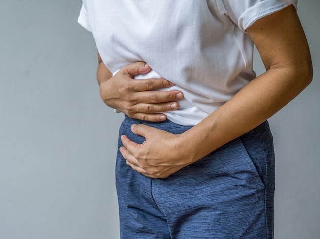 Una mujer se toca el abdomen como símbolo de malestar digestivo