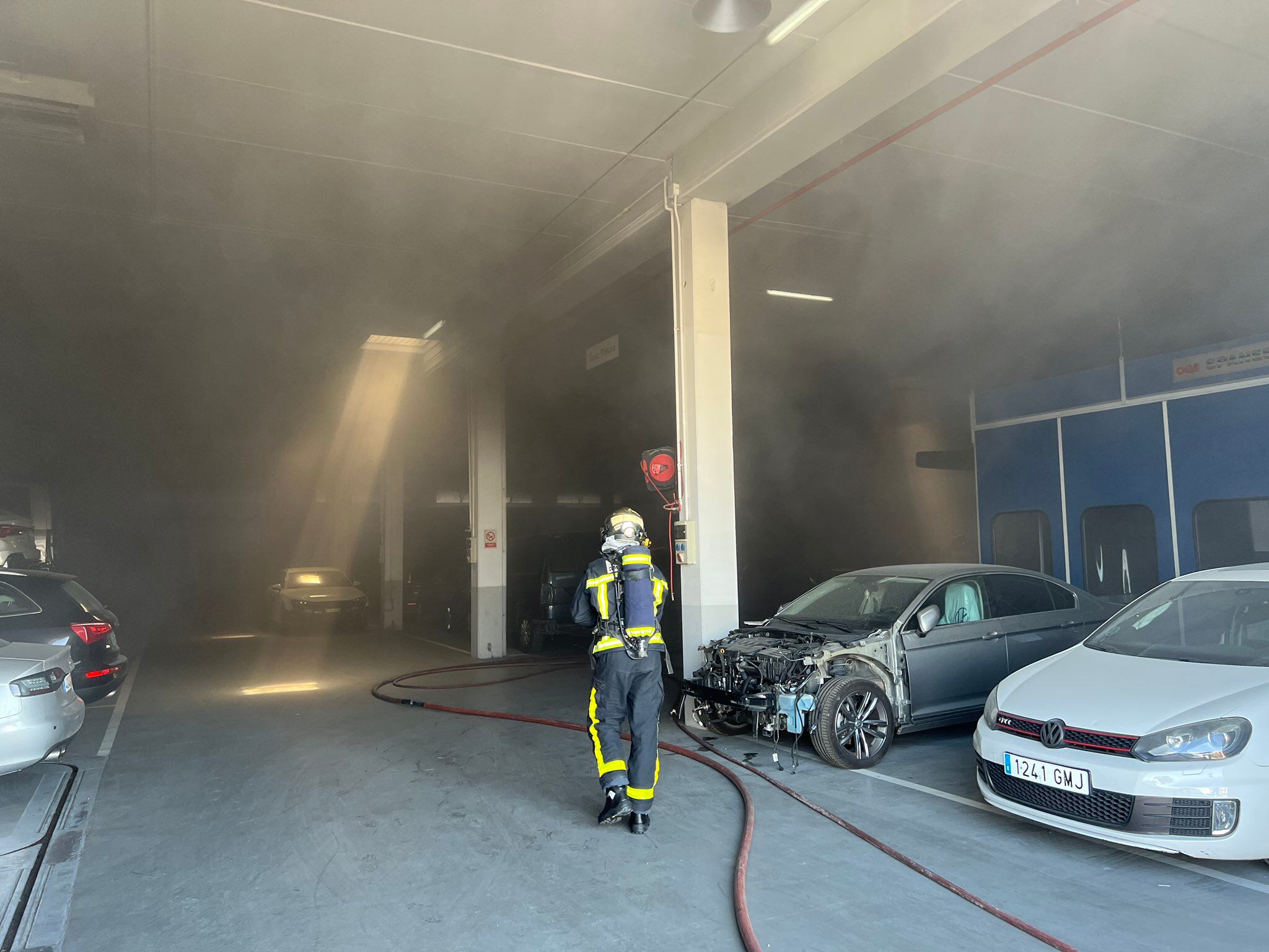 Los bomberos sofocando el incendio en el interior del concesionario