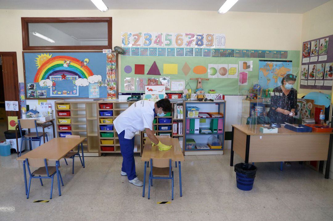 Una limpiadora desinfecta un aula en un colegio. Archivo