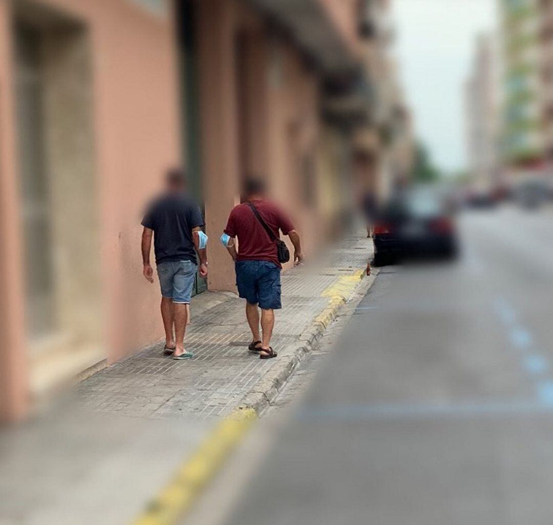 Dos veciinos de Gandia con la mascarilla en los codos