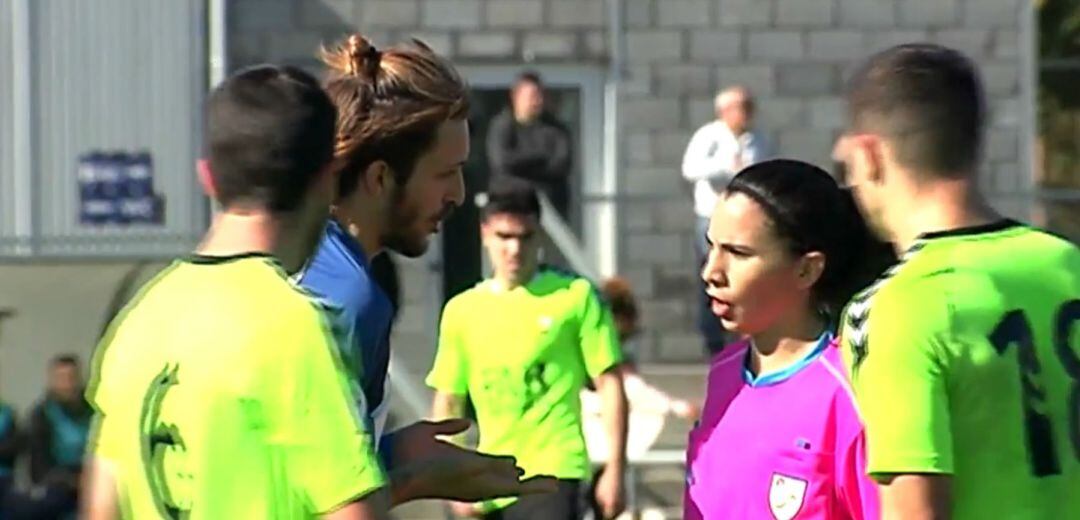 Ainara Acevedo trata de explicarle una jugada a uno de los futbolistas