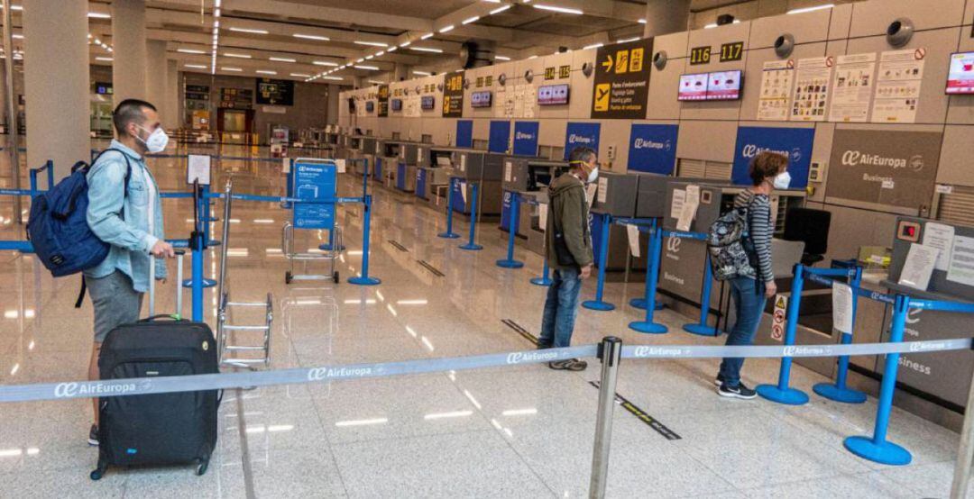 Viajeros manteniendo la distancia de seguridad en los mostradores de facturación del Aeropuerto de Palma.