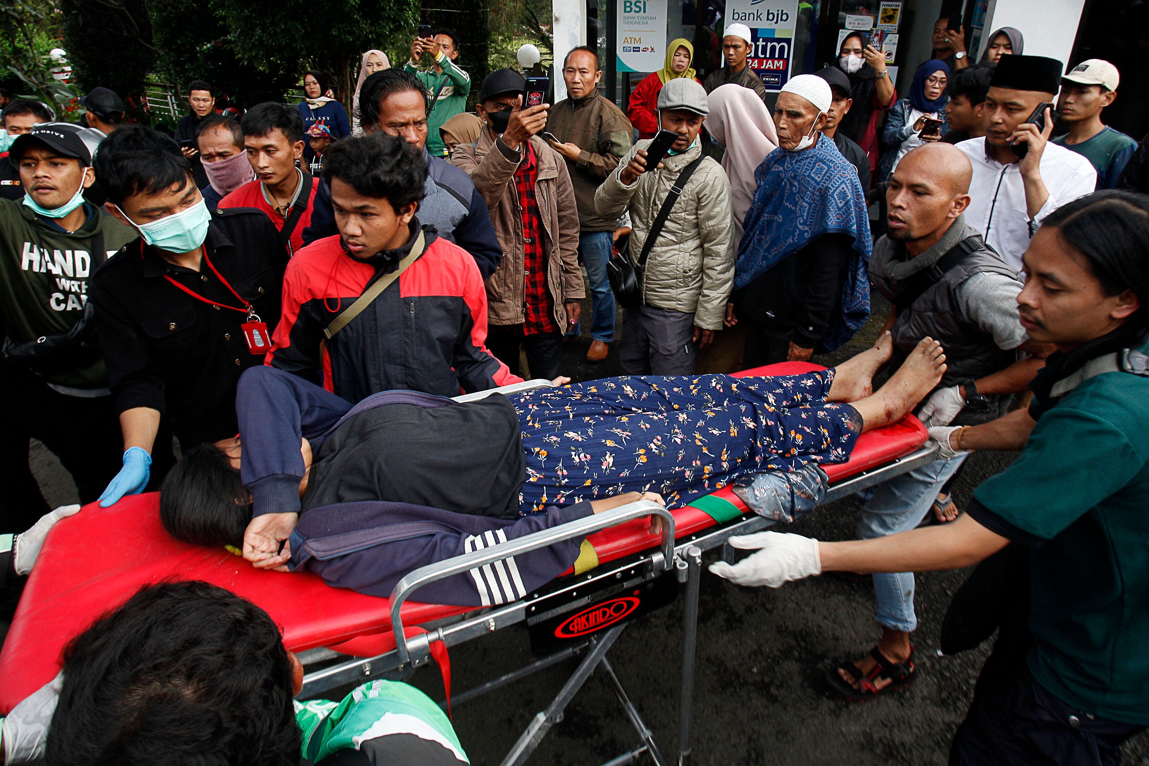 Ciudadanos evacuan a una mujer tras un derrumbe a causa del terremoto que ha sacudido este lunes Indonesia