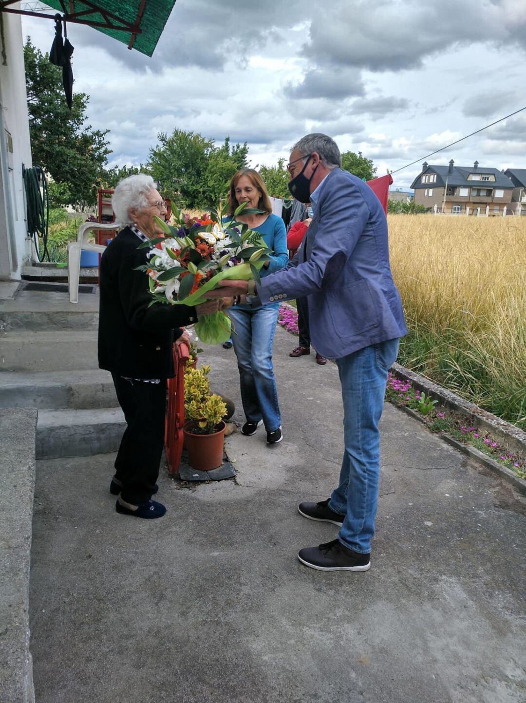 El pedáneo le hace entrega de unas flores