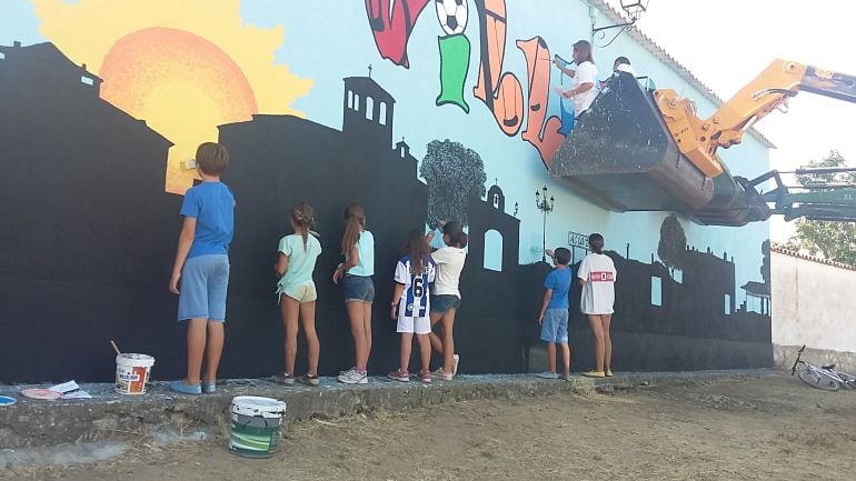 Niños pintan un mural en Villerías. 