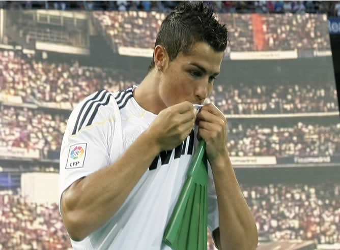 El futbolista Cristiano Ronaldo besa la camiseta durante su presentación en el Bernabéu.