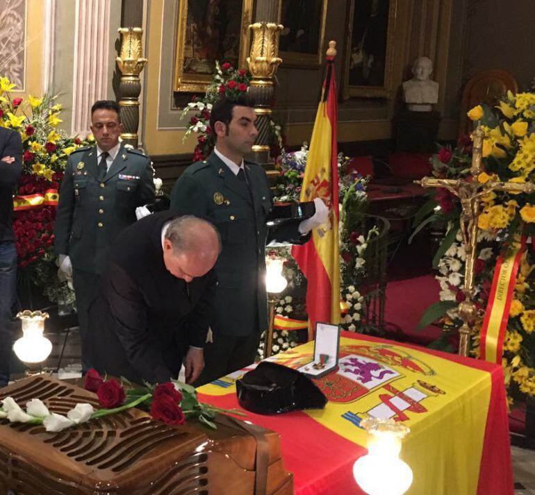 Fernández Díaz colocando la medalla sobre el féretro 