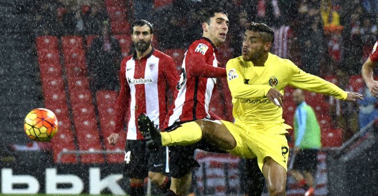 El jugador maexicano Jonathan Dos Santos (d) juega un balón ante Sabin (c), del Athletic Club, durante el partido de Liga en Primera División disputado esta noche en el estadio de San Mamés, en Bilbao.