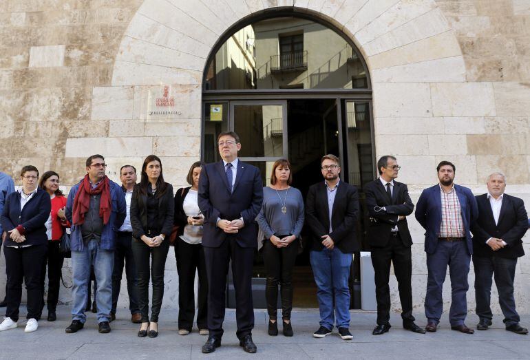 El president de la Generalitat, Ximo Puig (en el centro), y la presidenta de Baleares, Francina Armengol (a la izquierda de Puig), entre otras autoridades, guardan tres minutos de silencio ante la puerta del Palau en repulsa por la muerte, el domingo, de dos mujeres de Lliria en un nuevo caso de violencia machista