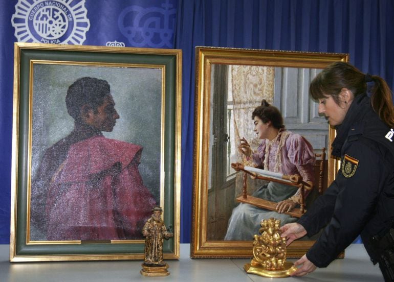 GRA041. SEVILLA, 16/01/2015.- Fotografía facilitada por la Policía Nacional de dos cuadros "La Bordadora" (d) de Ricardo López Cabrera y "Gitano" de Alfonso Grosso y una escultura de San Antonio de Sebastián Santos, que datan de principios de siglo xx y de alto valor económico que han sido recuperados después de que se hubieran sustraído de un domicilio de Sevilla. EFE/***SOLO USO EDITORIAL***
