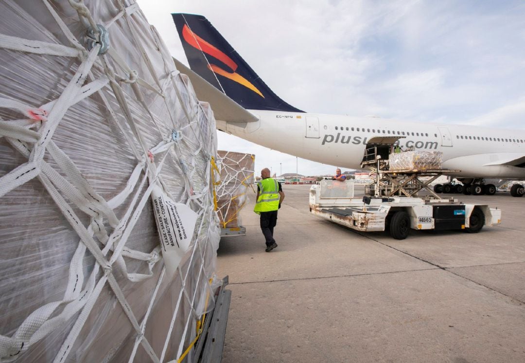 Operarios del aeropuerto de Gran Canaria descargan este sábado el avión que llegó hoy procedente de China en vuelo directo con material sanitario comprado por el Gobierno de Canarias para los centros sanitarios y sociosanitarios del Archipiélago