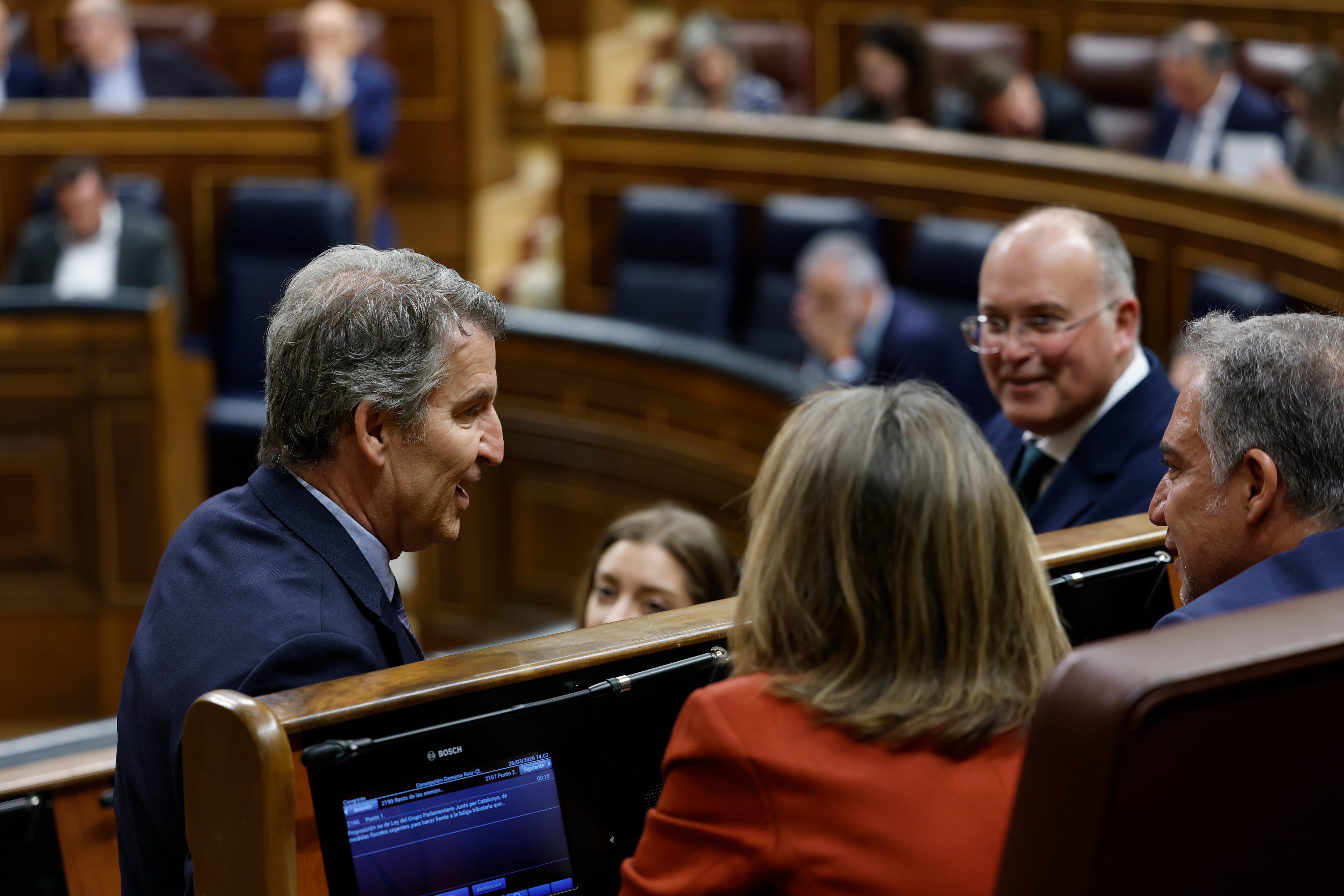 MADRID, 26/03/2026.- El líder popular Alberto Núñez Feijóo (i), conversa con sus diputados durante el pleno en el Congreso de los Diputados, este jueves. EFE/ Chema Moya