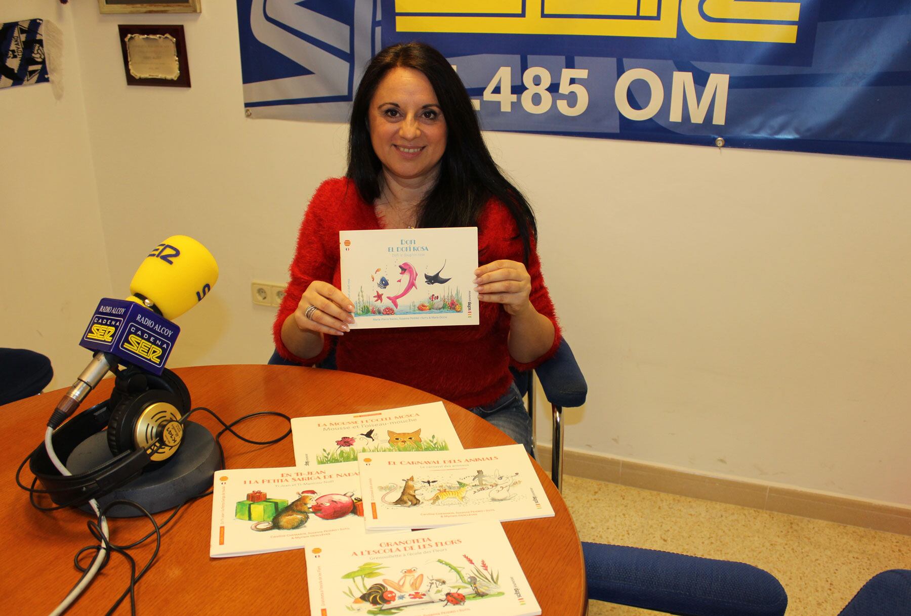 Susanna Peidro mostra un exemplar de la última publicació junt a llibres anteriors de la mateixa col·lecció