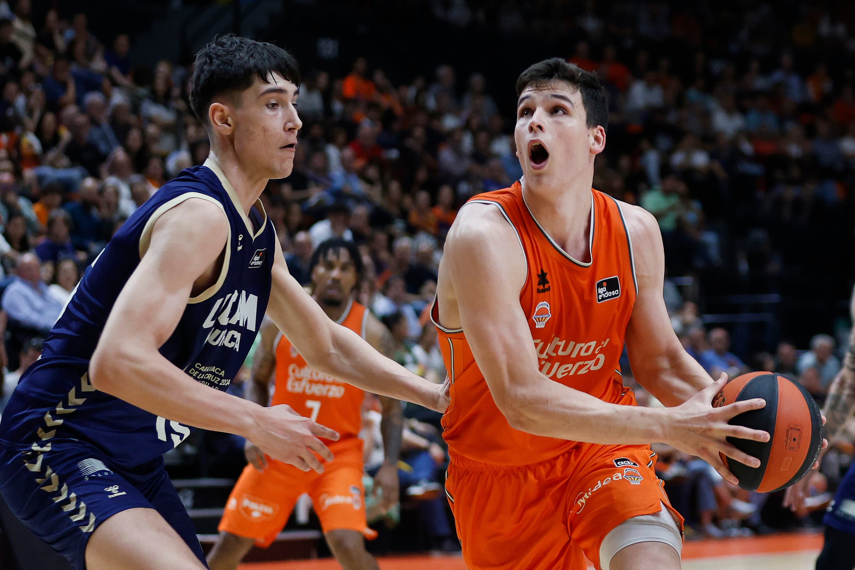 El alero Jaime Pradilla (d) del Valencia Basket en acción ante el pívot Fabian Sánchez Flores del UCAM Murcia, durante el primer partido de play offs de cuartos de final de la Liga Endesa de Baloncesto, entre el Valencia Basket y UCAM Murcia, disputado este sábado, en el pabellón de la Fuente de San Luis de Valencia.