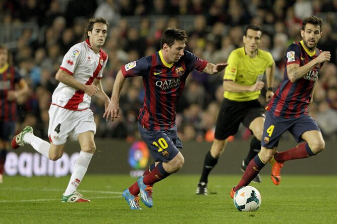 El delantero argentino del FC Barcelona Leo Messi avanza con el balón junto a Saúl y Raúl Baena, del Rayo Vallecano