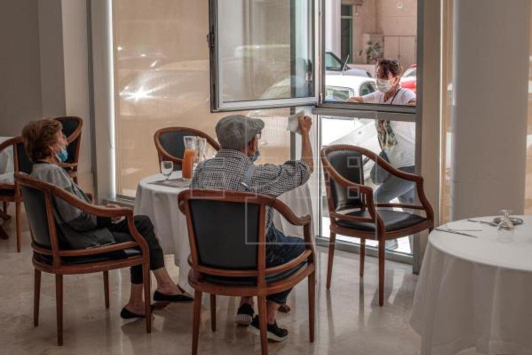 Dos ancianos residentes charlan con una viandante